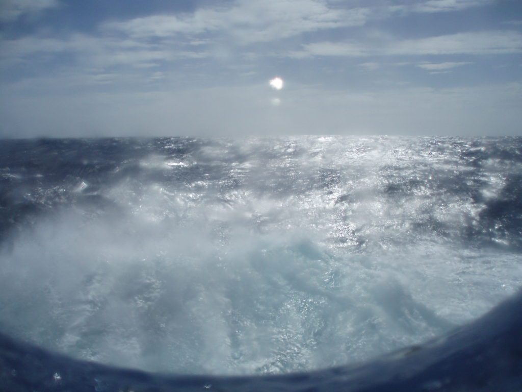 Waves battering against ship porthole