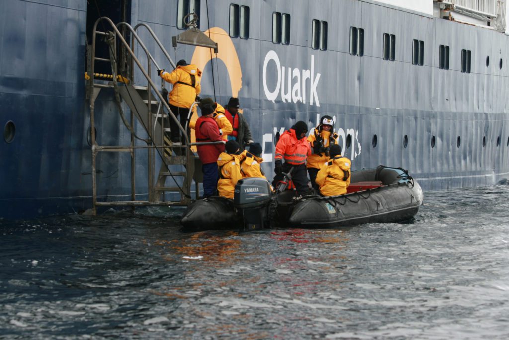 People boarding smaller boats from ship