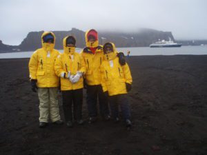 Family posing in front of Antarctic landscape