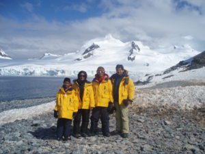Family posing in front of Antarctic landscape