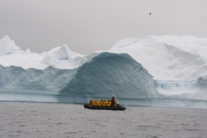 Boat with passengers and iceberg in water
