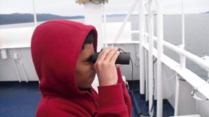 Teenager looking through binoculars