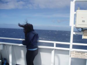 Woman with hair blowing on ship deck