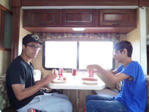 Teenagers eating hotdogs and drinking Coke