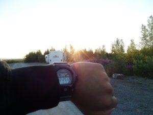 Wrist with watch showing 12:25 AM with sun in the sky in Northwest Territories