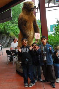 Kids posing in front of bear taxidermy